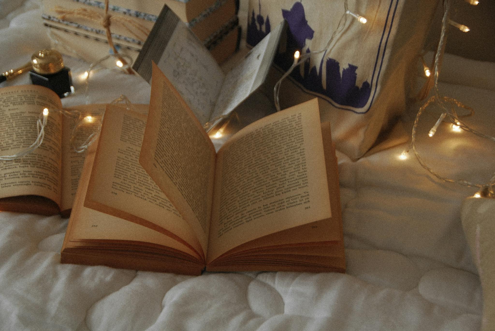 A cozy reading setup with an open book surrounded by warm fairy lights